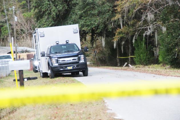 A van from the Florida Department of Law Enforcement stands beside the woods where authorities Wednesday were investigating recently discovered human remains.