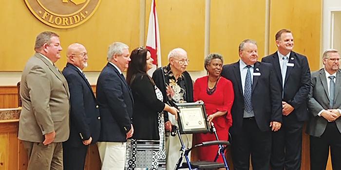 The Putnam County Board of Commissioners and Putnam County Library System Director Stella Brown award Wills for his work while his daughter, Tori Rayfield, stands beside him.