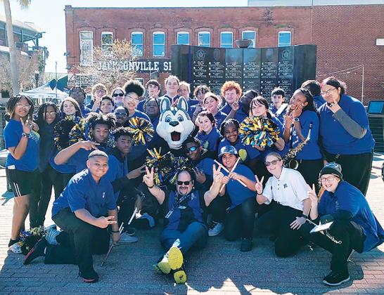 Palatka Junior-Senior High School band members smiles as they pose with the Jacksonville Iceman mascot, Fang, when the band performed at the arena hockey game.