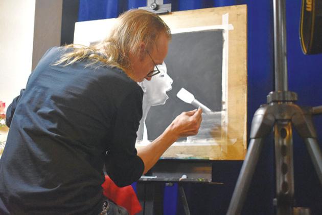 Artist Luke Taft uses charcoal to draw a portrait of singer and civil rights activist Nina Simone that was auctioned off at the end of the ceremony.