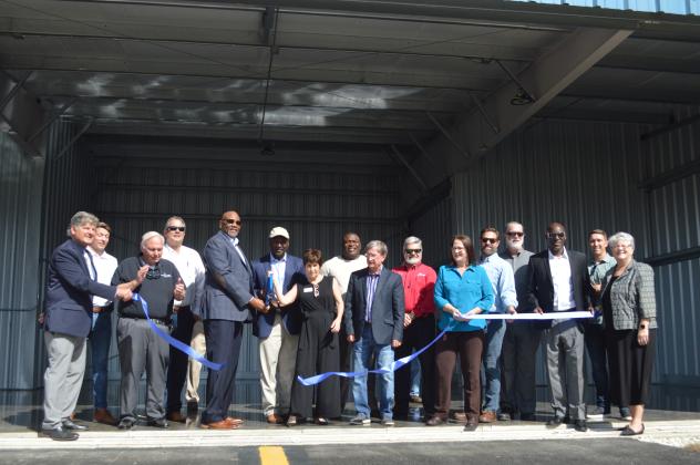 Officials with the City of Palatka and the Palatka Municipal Airport join flight enthusiasts, Airport Advisory Board members and others in cutting the ribbon on six new hangars at Lt. Jasper Kennedy "Kay" Larkin Field at the airport Wednesday. CASMIRA HARRISON/Palatka Daily News