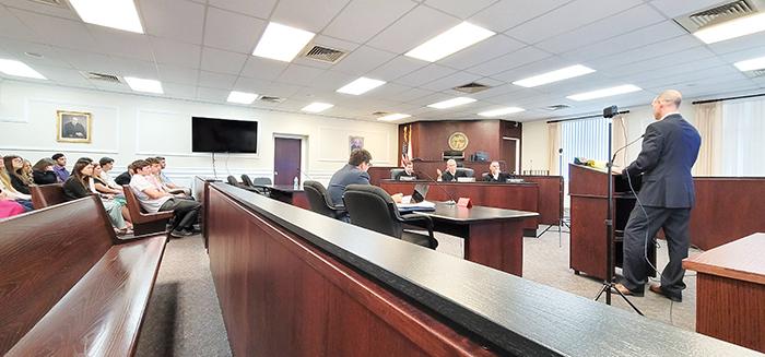 Attorney Ryan Jones, right, at lecturn, argues his case in support of Tower Hill Select Insurance Company to Fifth District Court of Appeal judges, center, as apellant attorney Geoffrey Marks, seated, and students of Peniel Academy listen. It was the first time the appellate court has heard arguments at the Putnam County Courthouse and local students got the rare chance to hear about the court system from the judges themselves.