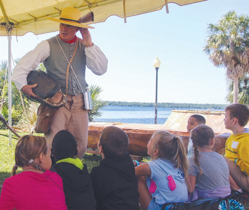 A historical reenactor portraying William Bartram shows Putnam County second graders an alligator head Tuesday during the Bartram Frolic along the St. Johns River in Palatka.