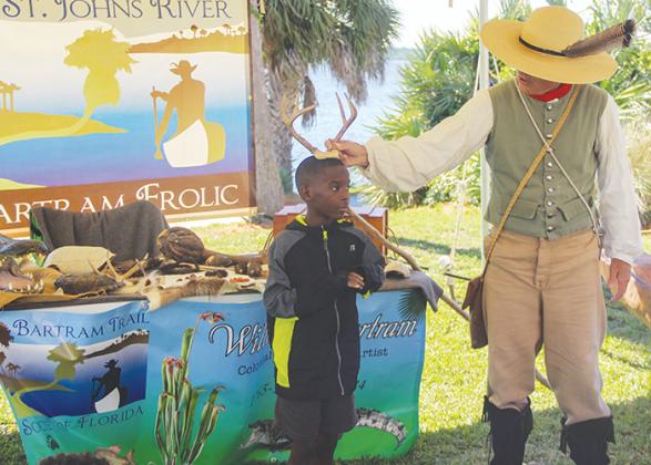 Robert H. Jenkins Elementary School second grader Ronald Ismon helps William Bartram teach other second graders about Florida wildlife, such as male deer, which Ismon is portraying Tuesday.