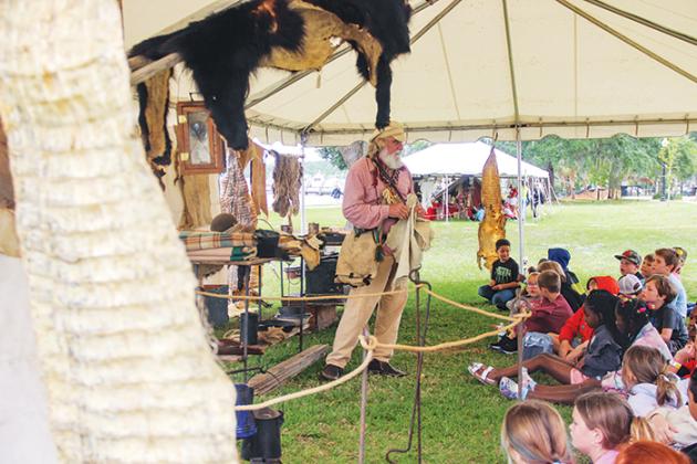 A historical reenactor portraying trader Job Wiggens teaches Putnam County second graders about trading goods.