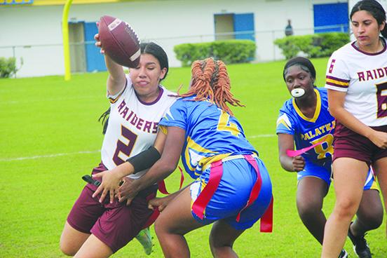Crescent City’s Paola Cruz stretches out for a first down as Palatka’s Titiana Peeples (4) looks to pull the flag during Wednesday night’s game at Bennett-Cooper Field at Veterans Memorial Stadium, won by the Raiders, 12-0. (COREY DAVIS / Palatka Daily News)