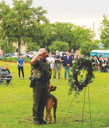 A sheriff’s office K-9 deputy and his handler pay their respects to a fallen Florida K-9 officer.