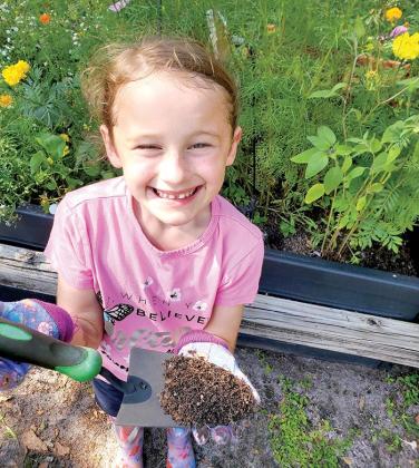 To plant her garden, Annabelle Price, seen here showing off one of her gardening tools, had to make sure she had plenty of dirt, seeds and kid-sized gardening tools for the task at hand.