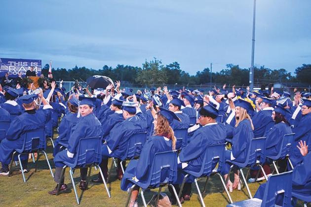 Graduates wave to their loved ones during the ceremony.