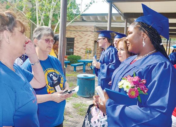 Mellon Learning Center employees talk with one of the school’s graduates after the commencement ceremony Monday afternoon.