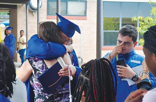 One of Mellon’s graduates hugs a family member after Monday’s graduation ceremony.