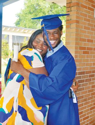 A Mellon graduate hugs his loved one after the school hosted its class of 2023 graduation ceremony. 