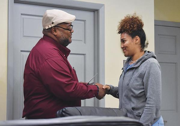 Palatka Housing Authority President and CEO Anthony Woods congratulates Raven Bramlitt during a graduation celebration Wednesday at the agency's headquarters in Palatka.