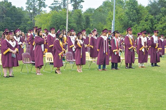 Crescent City Junior-Senior High School graduates listen as their classmate, Jabin Wright, gives the invocation during the school's commencement ceremony Thursday evening.
