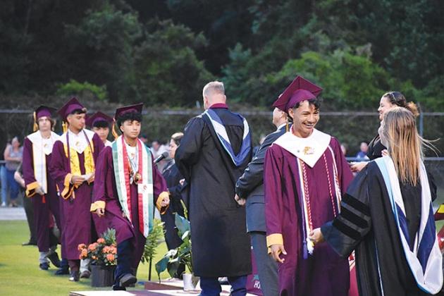 A Crescent City Junior-Senior High School graduate prepares to hug one of the school's administrators after receiving his diploma at the commencement ceremony.