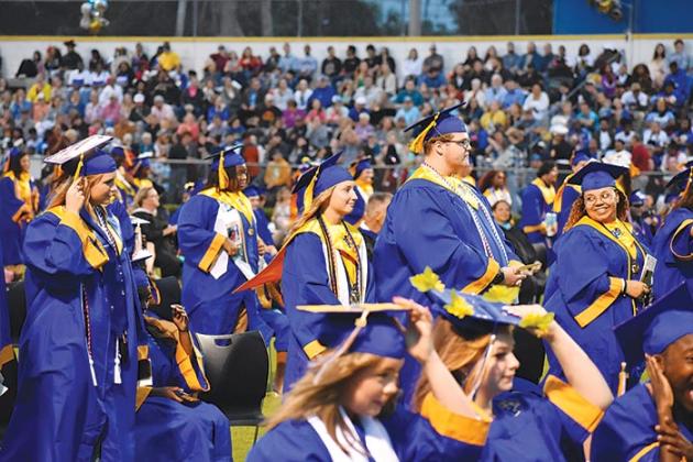 BRANDON D. OLIVER/Palatka Daily News  Palatka Junior-Senior High School graduates hold on to their caps and gowns during a windy commencement ceremony Friday evening.