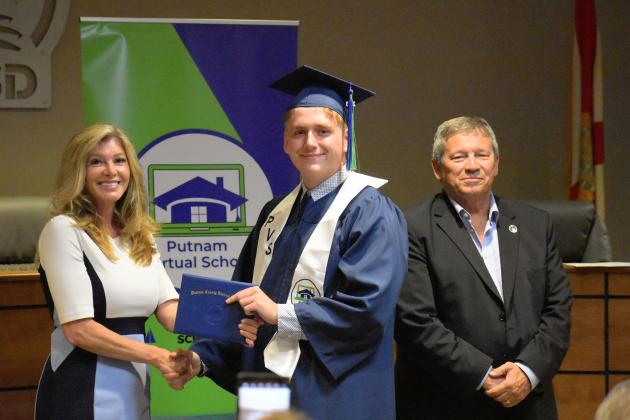 Matthew Elkins, center, receives his Putnam Virtual School diploma from Principal Mary Wood while Superintendent Rick Surrency stands with them.