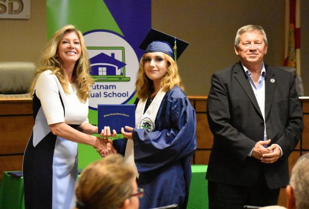 Pepper Grubbs, center, receives his Putnam Virtual School diploma from Principal Mary Wood while Superintendent Rick Surrency stands with them.