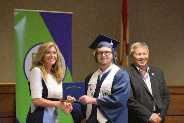 Matthew Hamby, center, receives his Putnam Virtual School diploma from Principal Mary Wood while Superintendent Rick Surrency stands with them.