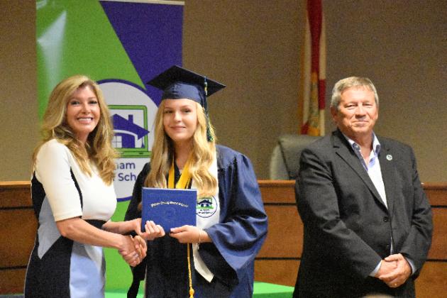 Samantha Sparks, center, receives his Putnam Virtual School diploma from Principal Mary Wood while Superintendent Rick Surrency stands with them.