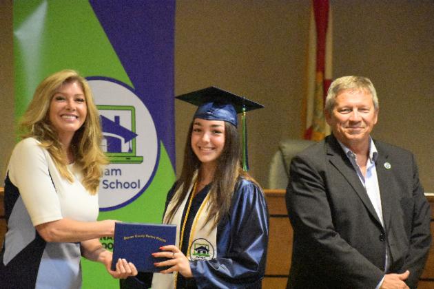 Peyton Van Horn, center, receives his Putnam Virtual School diploma from Principal Mary Wood while Superintendent Rick Surrency stands with them.