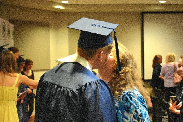 Putnam Virtual School graduate Matthew Elkins gives his mother, Kathryn Williams, a kiss on the cheek after his graduation ceremony. 