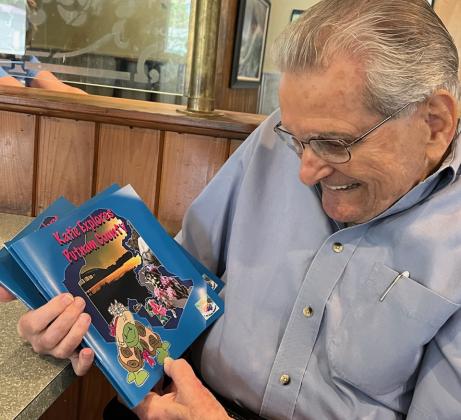 Danny Martinez is seen here getting the first peek at the new locally written and illustrated book dedicated to his late wife, Katie Martinez. (Photo courtesy of Angela Mills)