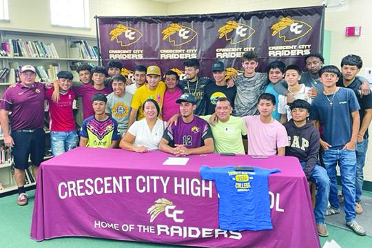 Two-time Daily News Boys Soccer Player of the Year Jesus Cruz (middle, sitting) is surrounded by family, coach Jeff Lease (far left) and all his Crescent City teammates after signing his letter of intent on Wednesday to play at Trinity Baptist College next year. (MARK BLUMENTHAL / Palatka Daily News)