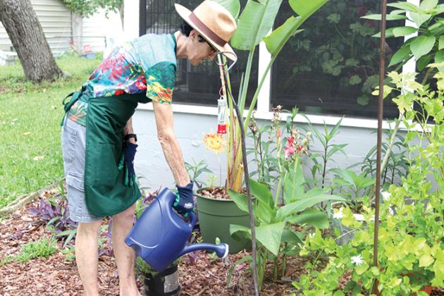 Photo by TRISHA MURPHY / Bliss waters the plants in her garden.