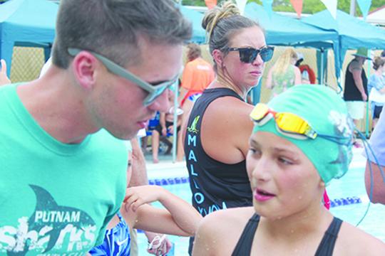 Putnam Sharks coach Jacob MacGibbon (left) talks with Shelby Malandrucco after she won her division 50-yard freestyle race on Saturday at the Putnam Aquatic Center. (MARK BLUMENTHAL / Palatka Daily News)