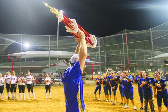 Palatka Babe Ruth 14-and-under softball all-star head coach Chris Barrett holds up the District 3 championship trophy Saturday after a 5-3 victory over Dixie County in Alachua. (COREY DAVIS / Palatka Daily News)