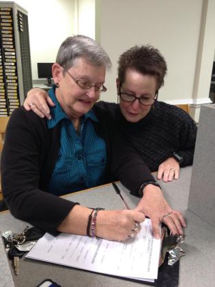 Photos courtesy of Judi Kosmar-Woods Judi and Marla Kosmar-Woods sign their marriage certificate on Jan. 6, 2015, at the Putnam County Courthouse on the first day same-sex marriage became legal in the state.
