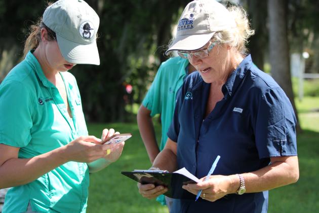 Riverkeeper intern Zoe Tressel, left, discusses findings in the St. Johns River with Jessica Finch, right, the Riverkeeper's Putnam County community engagement coordinator, in Welaka on Thursday. (CASMIRA HARRISON/Palatka Daily News)