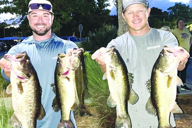 Adam Newburn (left) and Jason Reed hold up their winning fish at the recent 13th annual Corky Bell’s Thursday Evening Bass Tournament last week. (GREG WALKER / Daily News correspondent)