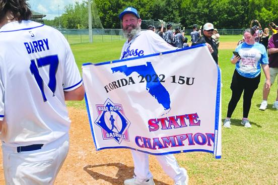 Dale Yarbrough holds the North Florida 15-and-under Babe Ruth baseball all-star championship flag after his team won the title last year. (MARK BLUMENTHAL / Palatka Daily News)
