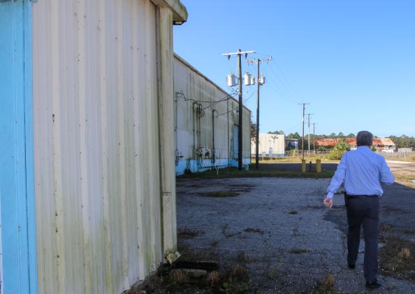 SARAH CAVACINI/Palatka Daily News. Port Manager Sam Sullivan walks across the Palatka Barge Port property, passing one of the site's warehouses and heading toward the second one in 2021.  