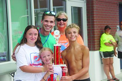 Putnam Sharks head coach Jacob MacGibbon (top left) and a few Sharks swimmers pose with the First Coast Summer Swim small league runnerup trophy. (COREY DAVIS/ Palatka Daily News)