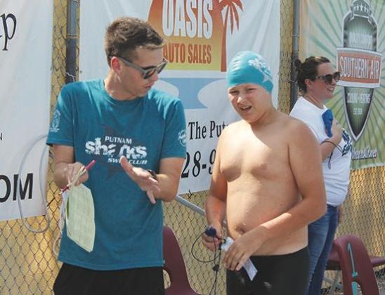 Putnam Sharks coach Jake MacGibbon talks with swimmer Dylan Fox during this past Saturday’s swim meet against Eagle Landing at the Putnam Aquatic Center. (MARK BLUMENTHAL/ Palatka Daily News) 