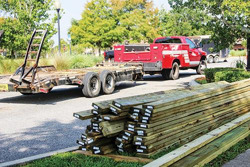 SARAH CAVACINI/Palatka Daily News -- Wooden planks at stacked at the Palatka riverfront Tuesday as workers carry out repairs on the boardwalk under Memorial Bridge.