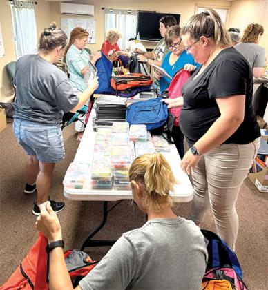 Photo submitted by Stephanie Anderson -- New Grace Baptist Woman’s Ministry and youth pack backpacks Wednesday evening with school supplies that will be given away Saturday at the Interlachen Soup Kitchen from 10 a.m. – 1 p.m.