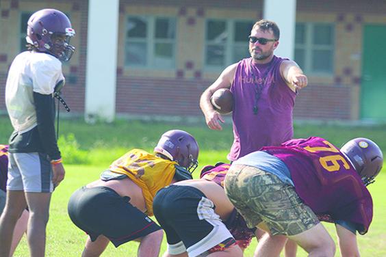 Crescent City assistant coach and athletic director Tim Ross points to offensive linemen while looking at Raiders quarterback Eric Jenkins Jr. in practice. (MARK BLUMENTHAL / Palatka Daily News)