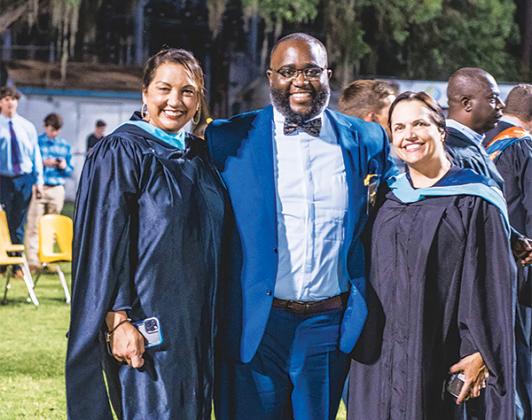 Photo courtesy of the Putnam County School District – From left, school district Administrator Sarajean McDaniel, Community Liaison Justin Campbell and Director of Community Relations Ashley McCool stand together at the 2021 graduation ceremony for Palatka Junior-Senior High School.