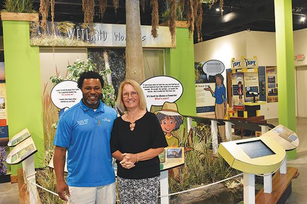 BRANDON D. OLIVER/Palatka Daily News – Cultural Arts Coordinator Courtney James, left, and Volunteer Coordinator Shann Purinton stand in front of a display at the St. Johns River Center in Palatka.
