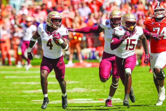 Kalen DeLoach (4) gets a pair of Florida State teammates, including Tatum Bethune, to block for him en route to a touchdown off a fumble return Saturday against Clemson. (GREG OYSTER / Special to the Daily News)