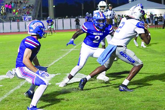 Interlachen’s Kaleb McKinnon tries to get away from Keystone Heights’ Cartez Daniels during the first half of Friday night’s game at Keystone Heights High School, won by the Indians, 46-8. (RITA FULLERTON / Special to the Daily News)