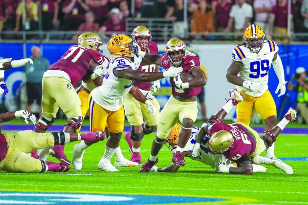 Florida State’s Trey Benson looks to escape the tackle attempt of LSU’s Sai’vion Jones during the Seminoles’ victory in Orlando on Sept. 3. (GREG OYSTER / Special to the Daily News)