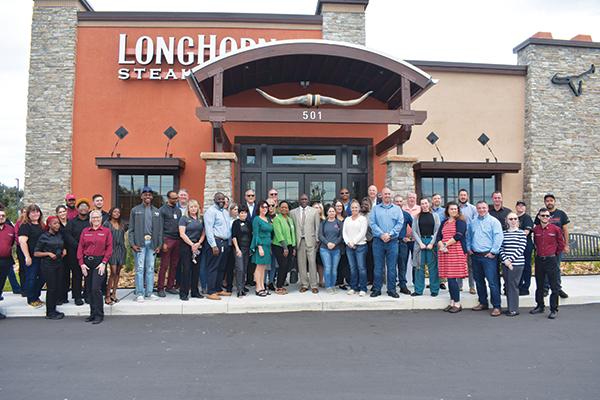 BRANDON D. OLIVER/Palatka Daily News – LongHorn Steakhouse officials and local business and government leaders stand outside the restaurant before the rope-cutting ceremony begins.