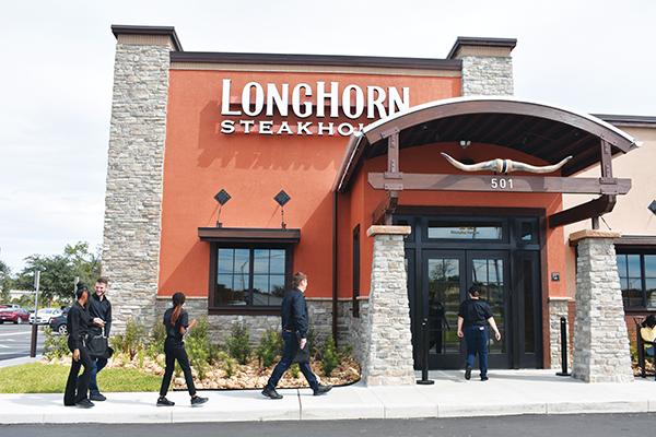 BRANDON D. OLIVER/Palatka Daily News – LongHorn Steakhouse employees make their way inside the restaurant about 20 minutes before it officially opened to the public at 3 p.m. Monday.