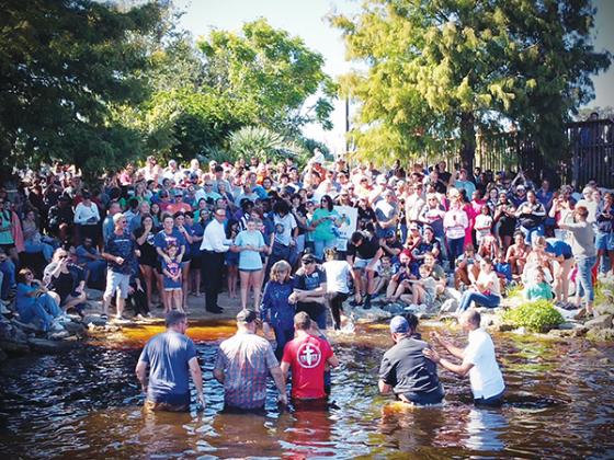 Photo submitted by Ricky Bybee – People gather at the Palatka riverfront Sunday to either cheer on the 160 people getting baptized or prepare to be baptized themselves.