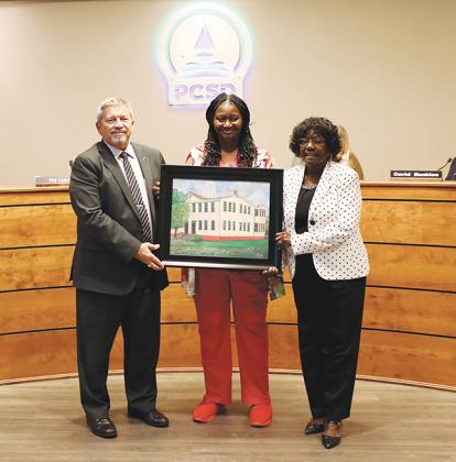 Photo submitted by Felicia Cahan – From left to right, Superintendent Rick Surrency, Gloria Lee and school board Chairwoman Sandra Gilyard hold a portrait of Central Academy that Lee’s husband painted. 